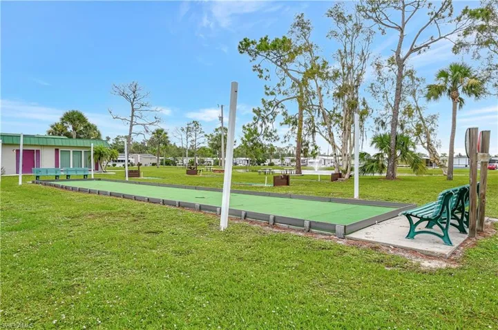View of home's community with a yard and a game area