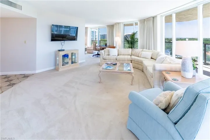 Living room featuring expansive windows and light colored carpet