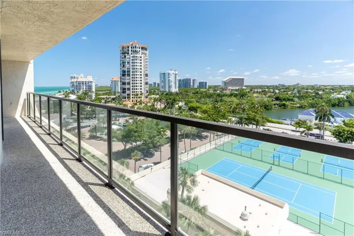 Balcony featuring a water view and tennis court