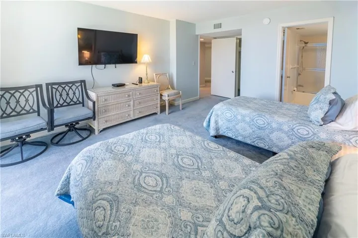 Bedroom with ensuite bath and carpet flooring