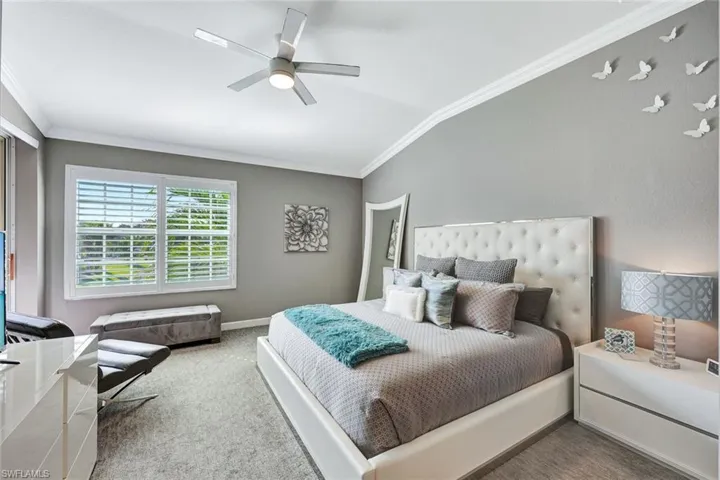 Bedroom with carpet, vaulted ceiling, ceiling fan, and ornamental molding