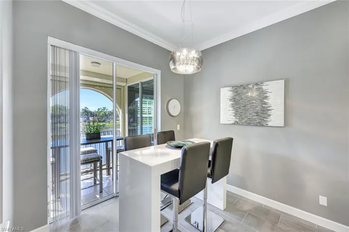 Breakfast room featuring crown molding, light tile patterned floors, and a chandelier