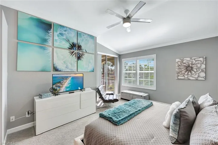 Bedroom with carpet, ceiling fan, ornamental molding, and vaulted ceiling