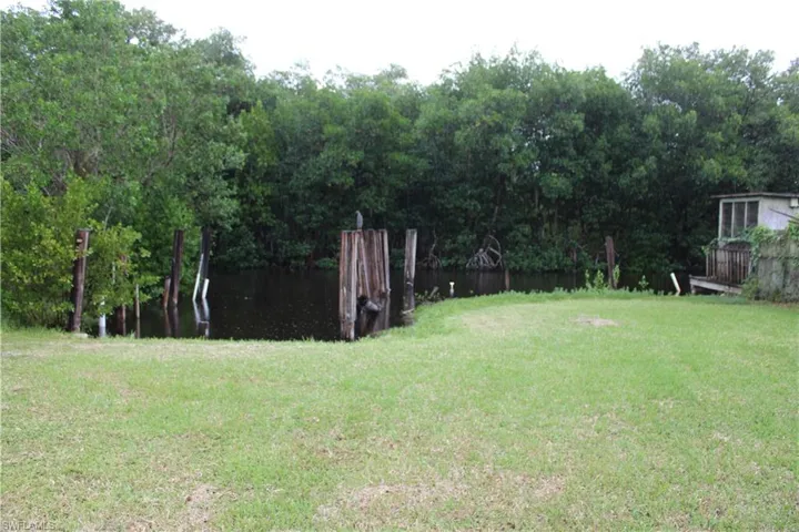 View of green lawn featuring a boat slip.