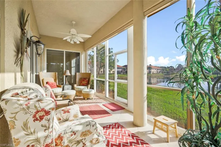 Sunroom / solarium with ceiling fan and a water view