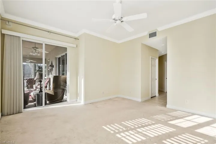 Unfurnished room featuring a ceiling fan, light carpet, and ornamental molding