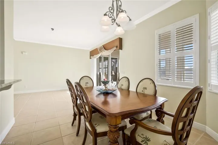 Dining space featuring ornamental molding, light tile patterned floors, and hanging lights
