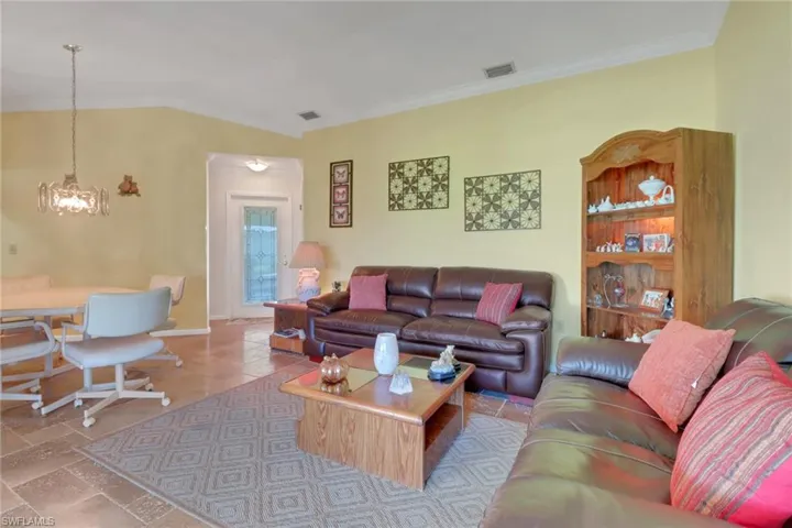Living area with ornhttps://www.canva.com/templates/?query=cover-letteramental molding, a ceiling fan, and a chandelier