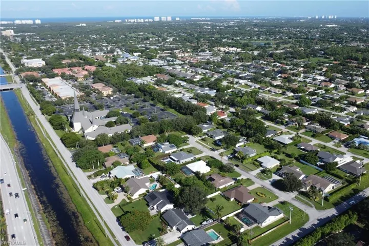Aerial view of property's location featuring a large body of water and nearby suburban area