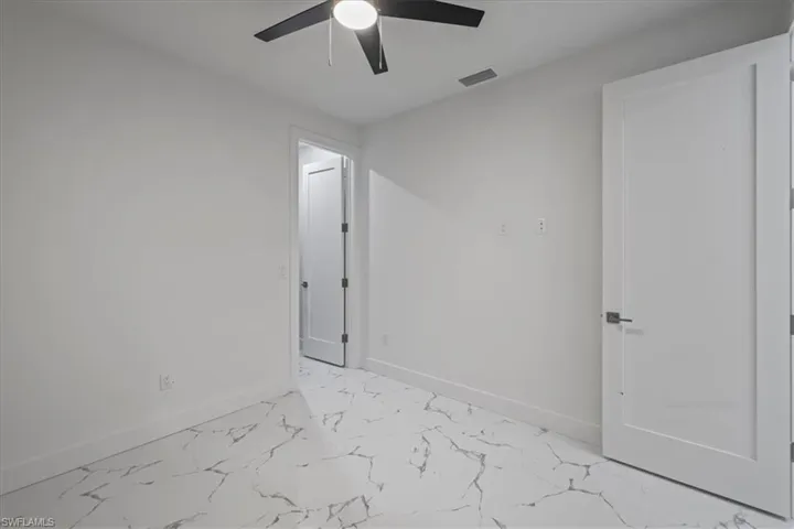 Unfurnished room with baseboards, marble finish floor, ceiling fan, and visible vents