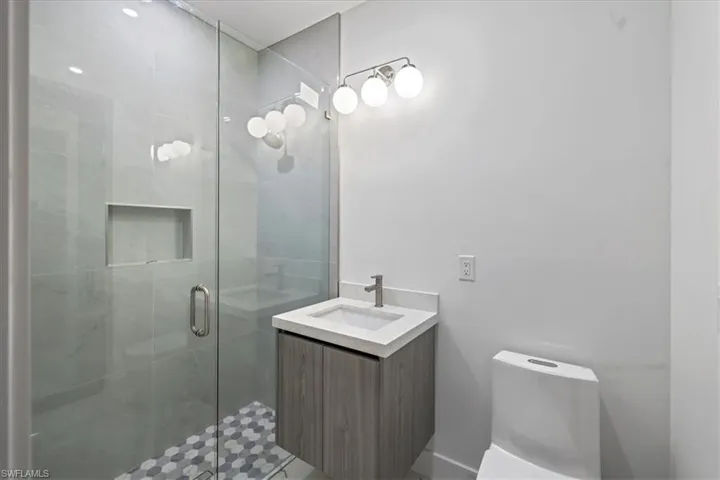 Bathroom with toilet, vanity, and a shower stall