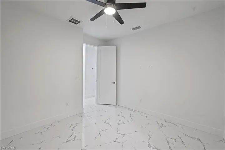 Unfurnished room featuring baseboards, ceiling fan, and visible vents