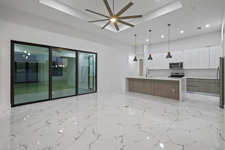 Kitchen featuring light countertops, a ceiling fan, white cabinetry, modern cabinets, and stainless steel appliances