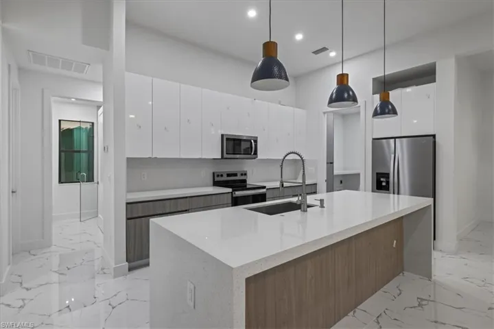 Kitchen featuring marble finish floor, modern cabinets, visible vents, and appliances with stainless steel finishes