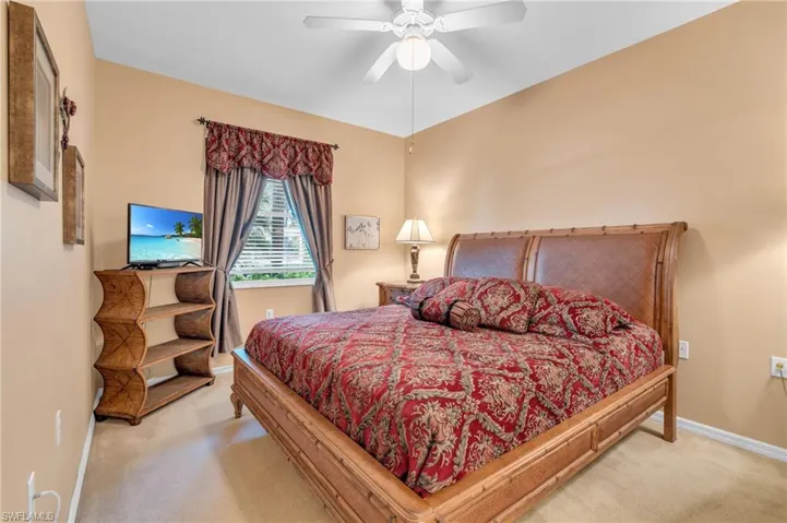 Carpeted bedroom with baseboards and ceiling fan