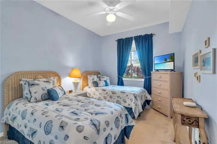 Carpeted bedroom featuring a ceiling fan