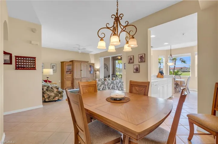 Dining room featuring light tile patterned floors, a chandelier, and a ceiling fan