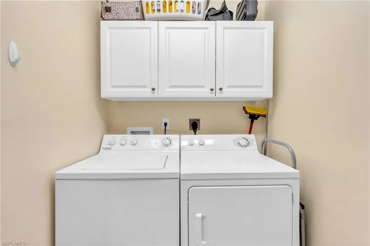 Laundry room featuring separate washer and dryer and cabinet space