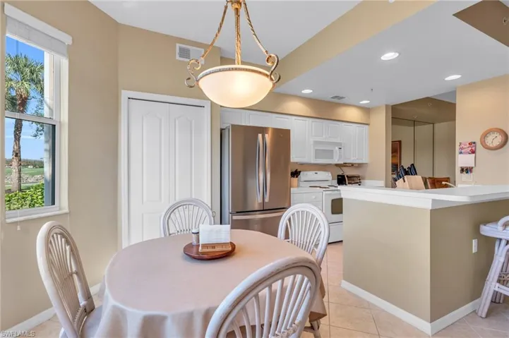 Dining area with light tile patterned flooring and recessed lighting