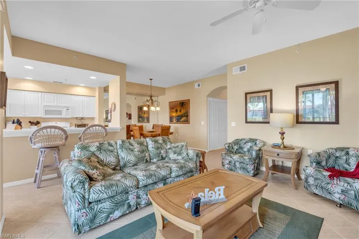 Living room featuring a chandelier, light tile patterned floors, arched walkways, recessed lighting, and a ceiling fan