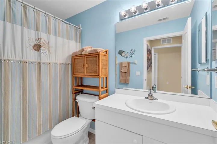 Bathroom featuring vanity and shower / bathtub combination with curtain