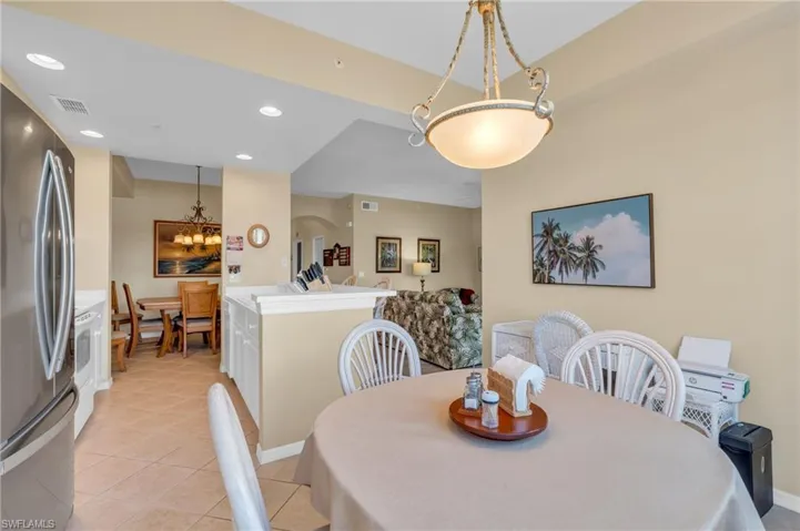 Dining space featuring recessed lighting, light tile patterned floors, arched walkways, and a chandelier