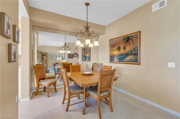 Dining room with light tile patterned floors and a chandelier
