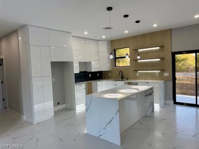 Kitchen with open shelves, modern cabinets, white cabinets, and pendant lighting
