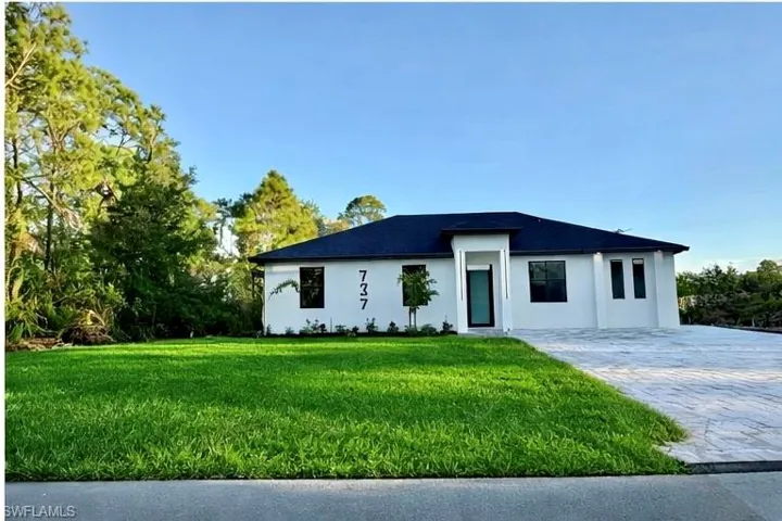 View of front of house with a front yard and stucco siding