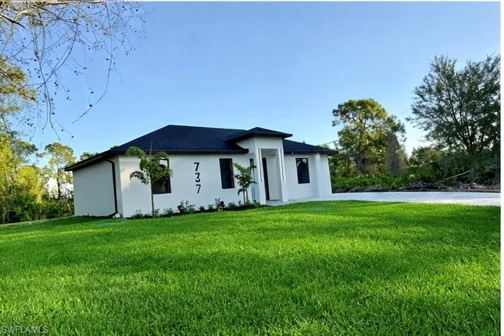 View of front of property featuring a front lawn and stucco siding