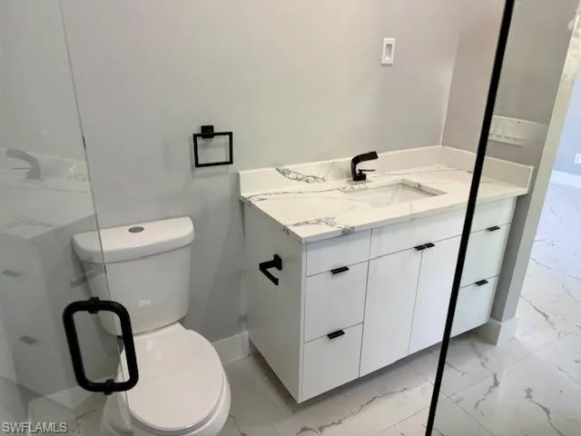 MASTER Bathroom featuring vanity and light marble finish floors