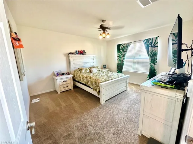 Carpeted bedroom with baseboards and a ceiling fan
