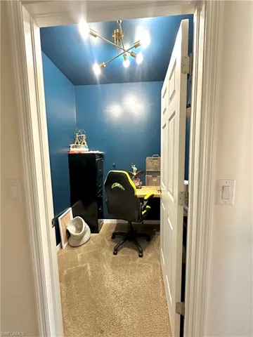 Carpeted office space with an inviting chandelier