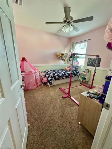 Carpeted bedroom featuring a ceiling fan