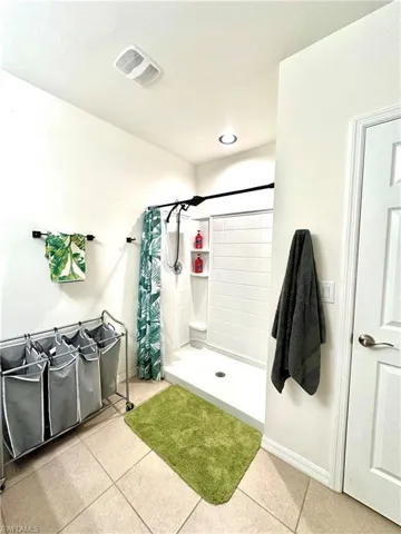 Full bathroom featuring a stall shower, baseboards, visible vents, and tile patterned flooring