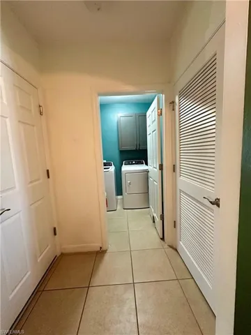 Hall featuring light tile patterned flooring and independent washer and dryer