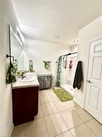 Full bath featuring visible vents, a stall shower, tile patterned floors, and vanity