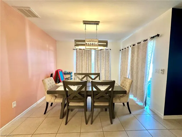 Tiled dining space with baseboards and visible vents