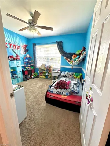 Carpeted bedroom featuring a ceiling fan