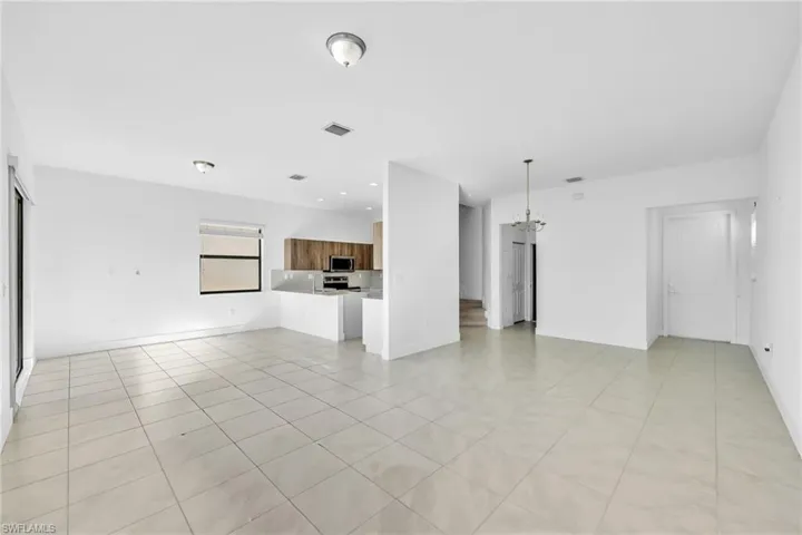 Living/Great Room featuring a chandelier, stairway, and light tile patterned flooring