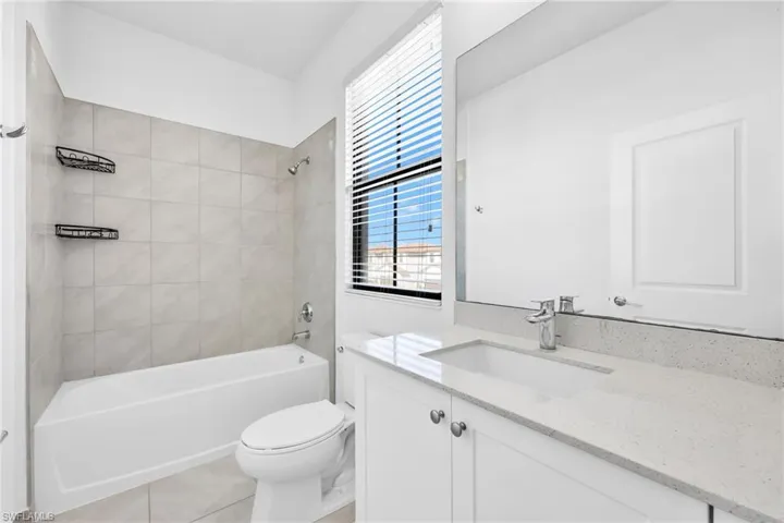 Full bathroom featuring shower / bathtub combination, vanity, and light tile patterned flooring