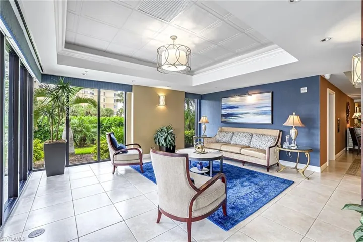 Tiled living area with a raised ceiling and crown molding