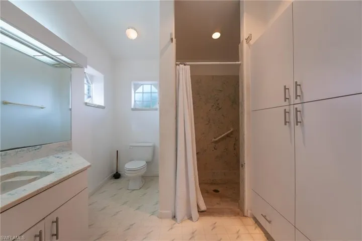 Bathroom with a shower stall, vanity, and light flooring