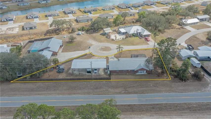 Aerial perspective of suburban area featuring property boundaries highlighted and a large body of water
