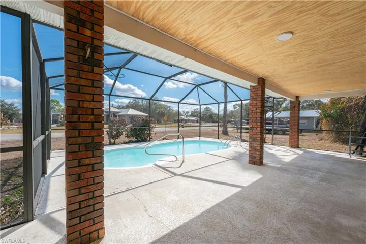 Outdoor pool with a lanai, a patio area, and a sunroom