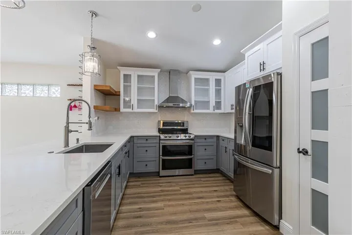 Chef's Kitchen with vented hood stove, quartz countertops, and pantry