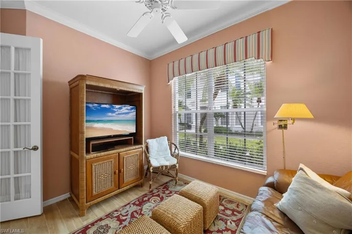 Living area with crown molding, wood finished floors, and ceiling fan