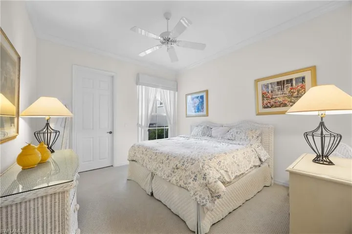 Bedroom with carpet flooring, crown molding, and a ceiling fan