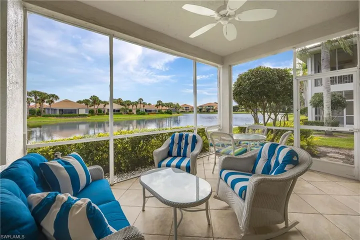 Sunroom / solarium featuring a water view, tile patterned flooring, and a residential view