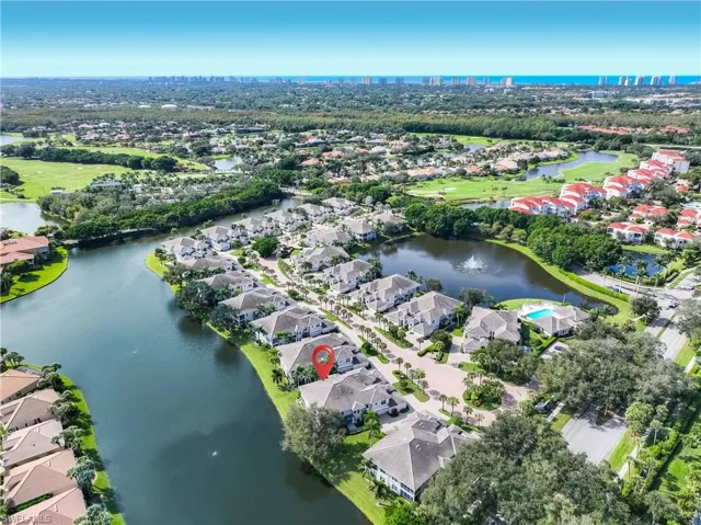 Aerial view of property and surrounding area with a nearby body of water and nearby suburban area